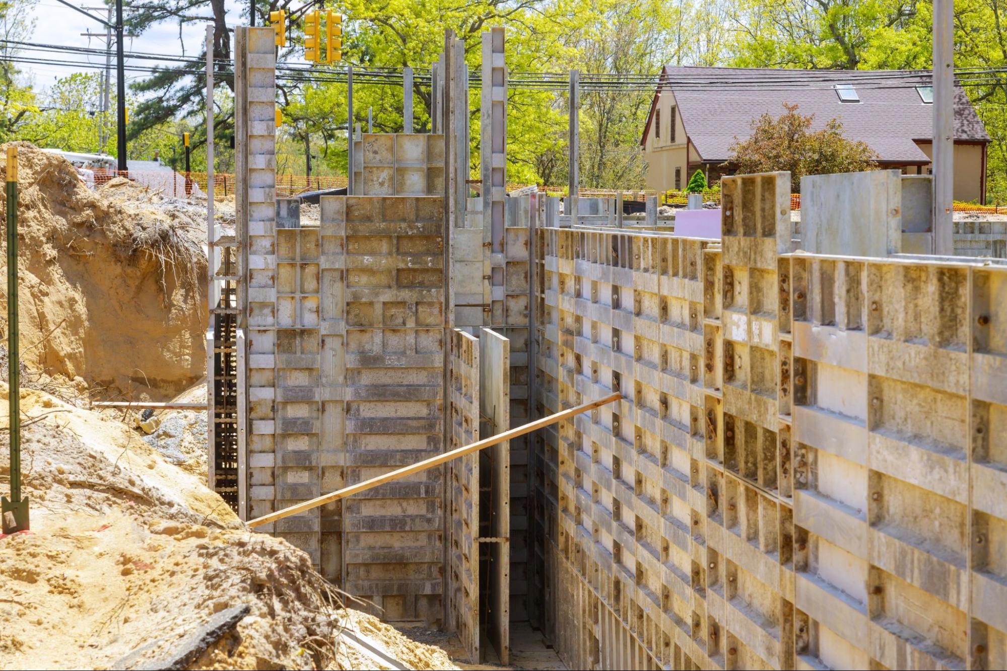 Concrete foundation strip with metal formwork prepared for a house build.
