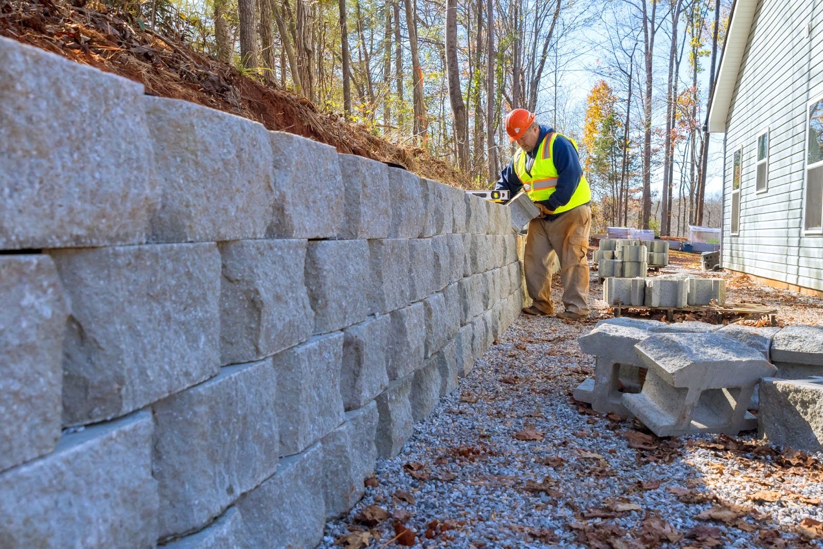 A construction worker is building a retaining wall.