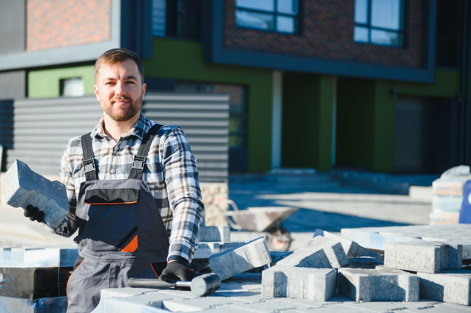 A masonry contractor installing a concrete block driveway with precision and alignment.