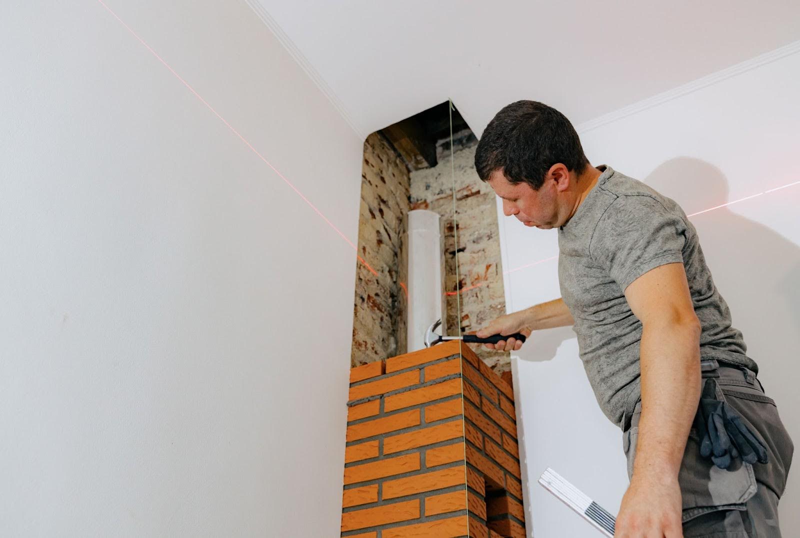 Skilled mason repairs the brickwork on a chimney.