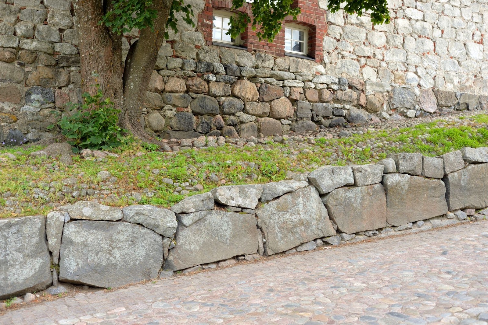A short retaining wall separates a raised bed from a walkway.