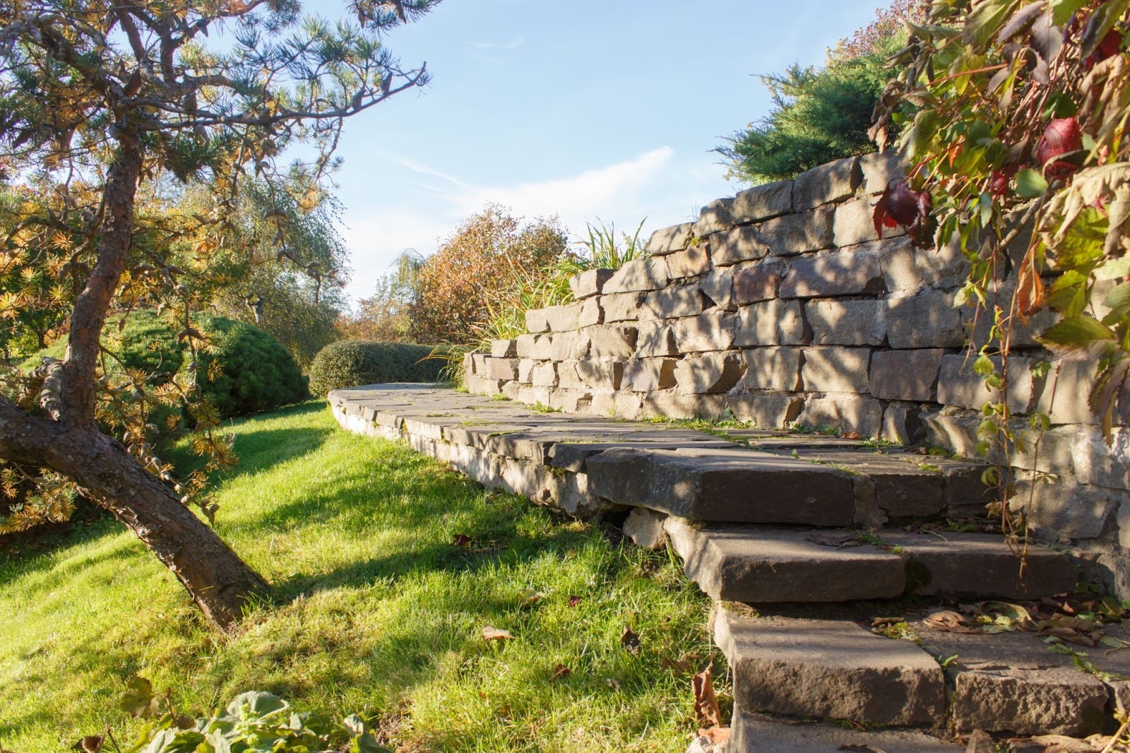 Stone garden stairs bordered by a natural stone retaining wall in a cottage-style landscape